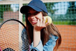 jovem jogador desportivo com raquete de tênis na quadra de tênis. foto