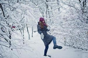 retrato de menina no dia de inverno nevado perto de árvores cobertas de neve. foto