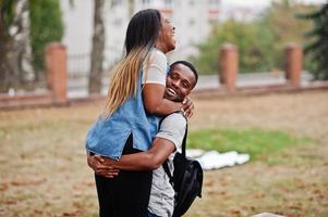 dois estudantes africanos com mochila no pátio da universidade abraços e se divertindo juntos. foto