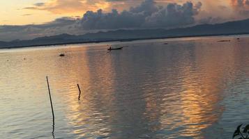 pescador em seu barco ao pôr do sol. barco de pescadores ao pôr do sol foto