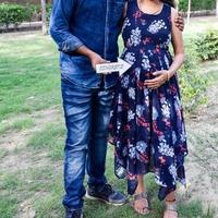 casal indiano posando para ensaio de maternidade. o casal está posando em um gramado com grama verde e a mulher está vacilando sua barriga no jardim lodhi em nova delhi, índia foto