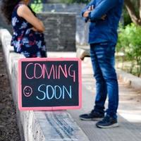 casal indiano posando para ensaio de maternidade. o casal está posando em um gramado com grama verde e a mulher está vacilando sua barriga no jardim lodhi em nova delhi, índia foto