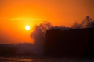 pôr do sol sobre o templo hindu pura tanah lot, bali, indonésia foto