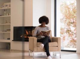mulher negra em casa lendo livro foto