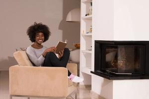 mulher negra em casa lendo livro foto