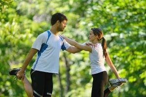 casal fazendo exercícios de alongamento depois de correr foto