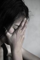 conceito de depressão ou violência doméstica, imagem grunge dessaturada de uma mulher adulta muito triste chorando foto