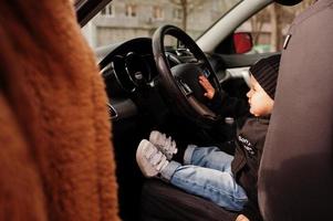 jovem mãe e filho no carro. conceito de condução de segurança. foto