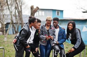 jovens amigos africanos da geração do milênio com telefones celulares. negros felizes se divertindo juntos. conceito de amizade de geração z. foto