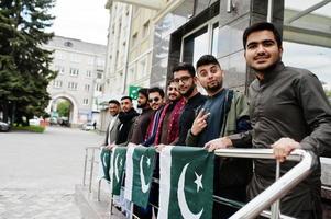 grupo de homem paquistanês vestindo roupas tradicionais salwar kameez ou kurta com bandeiras do paquistão. foto