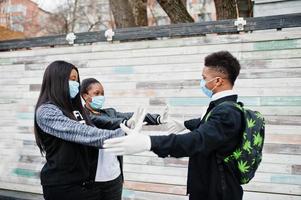 grupo de amigos adolescentes africanos usando máscaras médicas protegem contra infecções e doenças quarentena de vírus coronavírus. foto