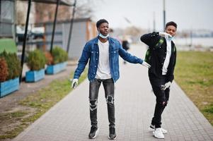 dois amigos adolescentes africanos no parque usando máscaras médicas protegem contra infecções e doenças quarentena de vírus coronavírus. foto
