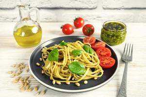 macarrão com molho pesto caseiro fresco e ingredientes alimentares foto