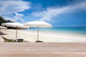 tampo da mesa de madeira no mar azul turva e fundo de praia de areia branca