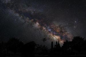 paisagem com via láctea, céu noturno com estrelas e silhueta do templo, fotografia de longa exposição, com grão foto