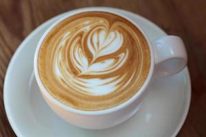café latte art em fundo de madeira foto