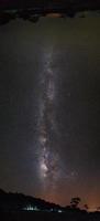 panorama Via Láctea e silhueta de árvore com nuvem. fotografia de longa exposição.com grão