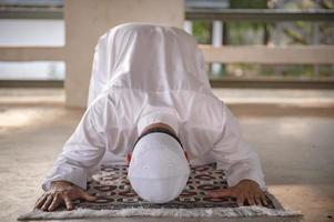 oração do homem islâmico asiático, jovem muçulmano rezando, conceito de festival do ramadã foto