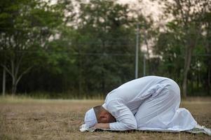 oração do homem islâmico asiático, jovem muçulmano rezando, conceito de festival do ramadã foto