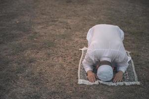 oração do homem islâmico asiático, jovem muçulmano rezando, conceito de festival do ramadã foto