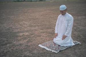 oração do homem islâmico asiático, jovem muçulmano rezando, conceito de festival do ramadã foto