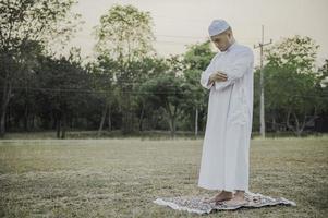 oração do homem islâmico asiático, jovem muçulmano rezando, conceito de festival do ramadã foto