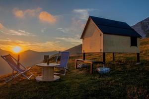 chalé de madeira nas montanhas ao pôr do sol foto