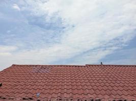 o telhado da casa com o sol quente e céu azul brilhante