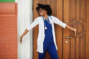 retrato de médica afro-americana com estetoscópio vestindo jaleco. foto