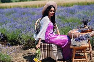 linda garota indiana usar vestido tradicional saree índia no campo de lavanda roxo. foto