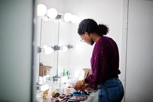 maquiador de mulher afro-americana no salão de beleza. foto