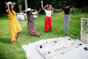 grupo de meninas afro-americanas comemorando festa de aniversário se divertindo e dançando ao ar livre com decoração. foto