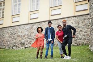 quatro amigos africanos se divertindo e dançando ao ar livre. duas meninas negras com caras. foto