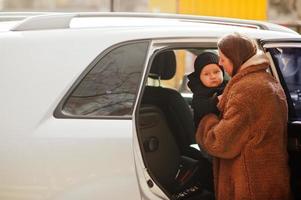 jovem mãe e filho ficam perto do carro suv. conceito de condução de segurança. foto