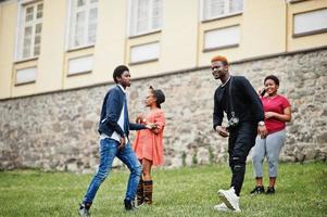 quatro amigos africanos se divertindo e dançando ao ar livre. duas meninas negras com caras. foto