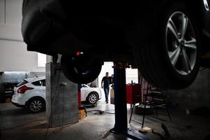 tema de reparação e manutenção de automóveis. mecânico de uniforme trabalhando em auto serviço. foto