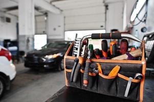 tema de reparação e manutenção de automóveis. mecânico de uniforme trabalhando em auto serviço. foto