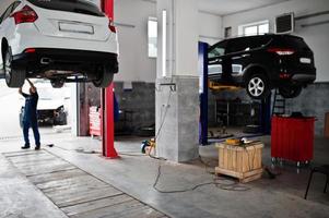 tema de reparação e manutenção de automóveis. mecânico de uniforme trabalhando em auto serviço. foto