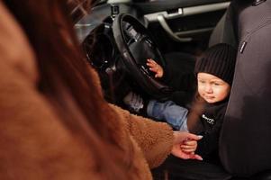 jovem mãe e filho no carro. conceito de condução de segurança. foto