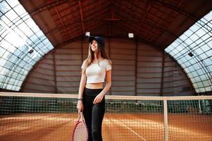 jovem jogador desportivo com raquete de tênis na quadra de tênis. foto