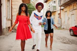 grupo de três amigos elegantes na moda afro frança posou no dia de outono. modelo de homem negro africano com duas mulheres de pele escura. foto