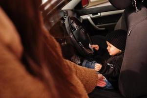 jovem mãe e filho no carro. conceito de condução de segurança. foto