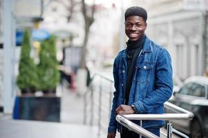 homem africano usa jaqueta jeans posada ao ar livre. foto