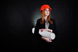 mulher engenheira em laranja proteger capacete com projeto de papel de construção. foto