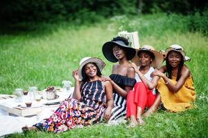 grupo de meninas afro-americanas comemorando a festa de aniversário ao ar livre com decoração. foto