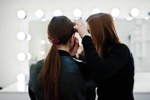 maquiadora trabalha em seu salão de beleza. mulher aplicando pelo mestre de maquiagem profissional. conceito de clube de beleza. foto