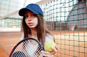 jovem jogador desportivo com raquete de tênis na quadra de tênis. foto