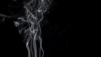 fumaça isolada em fundo preto. movimento de fumaça branca foto