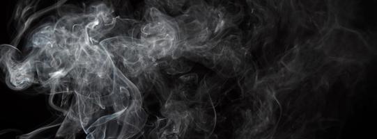 fumaça isolada em fundo preto. movimento de fumaça branca foto