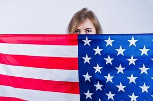 linda garota olhando da bandeira americana dos eua isolada no fundo branco. foto